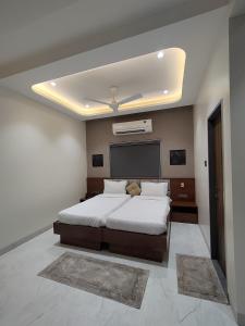 a bedroom with a large bed and a ceiling at Hotel Sundarai Lodging in Jāmkhed