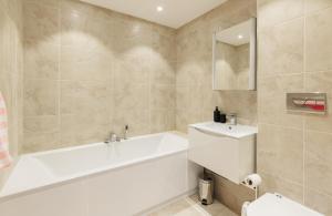 een badkamer met een wit bad en een wastafel bij Sun Rise in Sandown +45 foto's