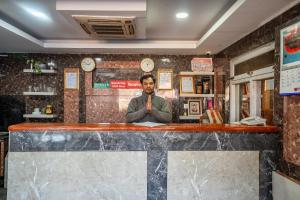 a man is sitting at a bar with his crossedhands at OYO 825 Hotel Baikuntha in Kathmandu