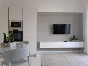 a white kitchen with a tv on a wall at Apartament and suite cavour 106 in Palermo