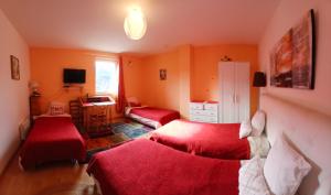 a living room with two beds and a desk and a room at Les Terrasses du Paradis in Orpierre