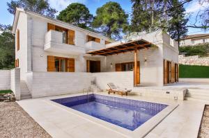 a house with a swimming pool in front of it at Private luxury Villa BIANCO on Solta for up to 10 persons, heated pool, free parking, very close to the beach! FREE Kajak & Mountainbikes, GREAT living area & privacy! in Rogač