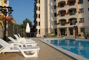 a hotel with a pool and lounge chairs next to a building at Hotel Seasons 3 in Sunny Beach