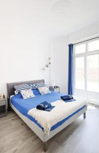 a bedroom with a bed with blue sheets and a window at Appartement 2 pieces in Nice