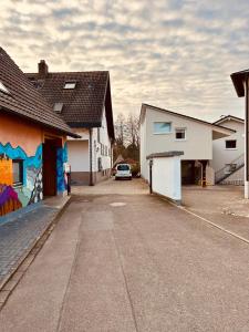 鲁斯特Family Apartments Abuja的两栋建筑之间的停车场停放的汽车