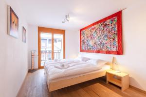 a bedroom with a bed with a large painting on the wall at Ski Paradise SP 008 - MOUNTAIN & LUXE apartment 4 pers in Veysonnaz