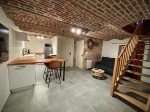 a kitchen and a living room with a table and a staircase at Le Domaine du Castel in Saulzoir +15 photos