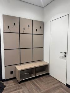 una habitación con un banco y una pared en Apartment on Mukanova street, en Karagandá