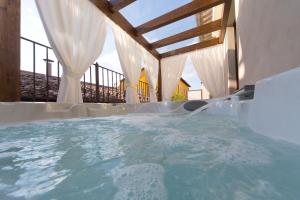 a jacuzzi tub in a room with curtains at Di Sabatino Resort - Suite Apartments & Spa in Ascoli Piceno