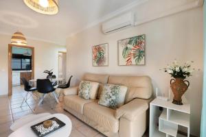a living room with a couch and a table at Golden Sands Apartment - Chiclana de la frontera in Novo Sancti Petri