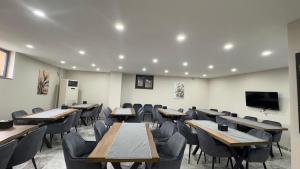 a classroom with tables and chairs and a flat screen tv at Lions Boutique Hotel in Altınova