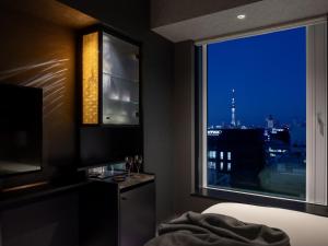 een slaapkamer met een groot raam met uitzicht op de stad bij Mitsui Garden Hotel Nihonbashi Premier in Tokyo +57 foto's
