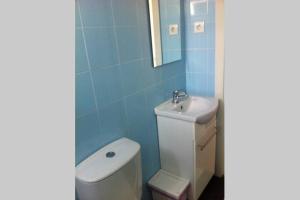 a bathroom with a white toilet and a sink at Casa dos Artistas in Caldas da Rainha