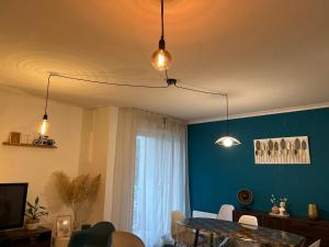 a living room with a table and a blue wall at Niort Home in Niort +17 photos