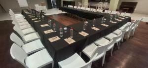 a row of tables and chairs with wine bottles on them at Indaba Hotel - Sasolburg in Sasolburg