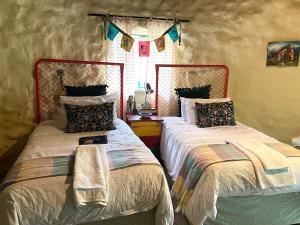 two beds sitting next to each other in a bedroom at ilyn pottery cottage in Pretoria +11 photos