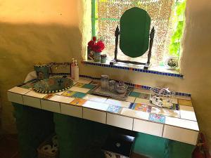 a bathroom counter with a mirror and a sink at ilyn pottery cottage in Pretoria