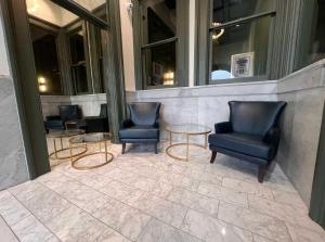 un vestíbulo con 2 sillas y 2 mesas en Bright and Modern Studio in Louisville # 106, en Louisville