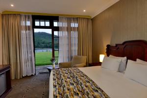 a hotel room with a bed and a large window at Troutbeck Resort in Nyanga +129 photos