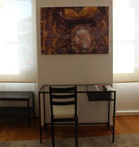 
a wooden table in front of a window with a painting on it at Domus 26 Guesthouse - B&B in Braga
