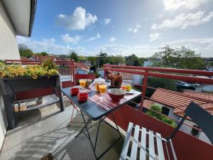 einen Balkon mit einem Tisch mit Speisen und Getränken in der Unterkunft Superbe appartement 4 personnes Arcachon Abatilles avec parking 500m plage Péreire in Arcachon