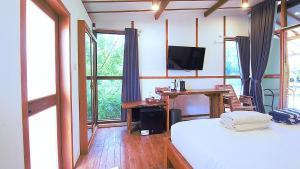 una camera da letto con un letto, una scrivania e una televisione di Serene Beach Villa a Gili Trawangan