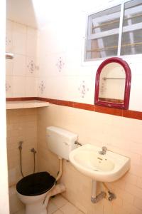 a bathroom with a toilet and a sink at Fort Garden Residency in Cochin