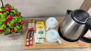 a table with a tea pot and a vase of flowers at Lions Boutique Hotel in Altınova