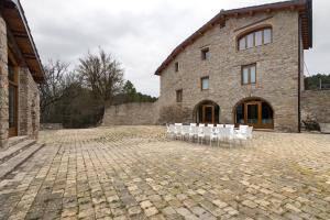 a row of white chairs in front of a building at Agroturisme La Serra in Vilada