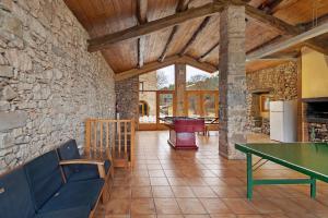 a living room with a table and a stone wall at Agroturisme La Serra in Vilada