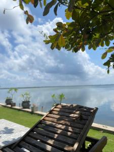 a wooden bench sitting in front of the ocean at Lagoon Bay Resort in Negombo