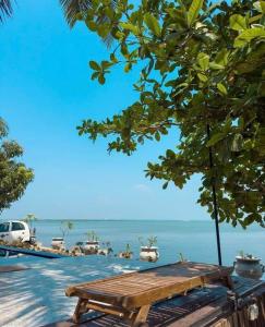 a wooden bench sitting in front of the ocean at Lagoon Bay Resort in Negombo