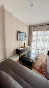 a living room with a couch and a glass table at cozy home in traquil area in Empangeni