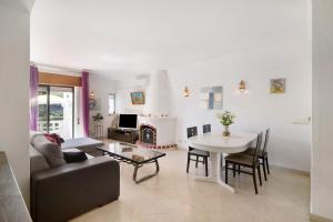 a living room with a table and a couch and a dining room at Apartamento Carvoeiro in Praia do Carvoeiro