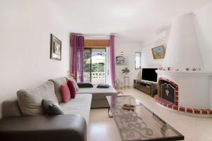 a living room with a couch and a fireplace at Apartamento Carvoeiro in Praia do Carvoeiro