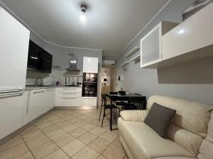 Una cocina y una sala de estar con un sofá y una mesa. en Alloggio Angelo Bovo 4, en Fiumicino