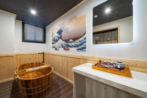 a sauna with a wooden tub and a large painting at Ryokan Stay in Gangneung