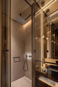 a bathroom with a shower with a sink and a mirror at Amathus Beach Hotel Limassol in Limassol