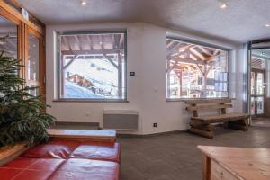 een woonkamer met een bank en twee ramen bij Résidence Pierre & Vacances Les Sentiers du Tueda in Méribel +49 foto's