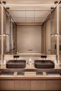 a bathroom with two sinks and a large mirror at Amathus Beach Hotel Limassol in Limassol