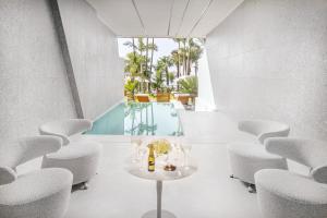 a room with a table and chairs and a pool at Amathus Beach Hotel Limassol in Limassol