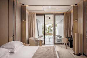 a hotel room with a bed and a desk and a living room at Amathus Beach Hotel Limassol in Limassol