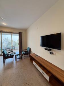 a living room with a flat screen tv on a wall at Wonder Mist Resort, Mahabaleshwar in Mahabaleshwar