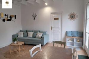 a living room with a blue couch and a table at Charmante Maisonnette Rénovée - 5 min d'Argenton Sur Creuse in Chabenet
