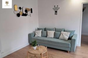 a living room with a blue couch and a table at Charmante Maisonnette Rénovée - 5 min d'Argenton Sur Creuse in Chabenet +11 photos