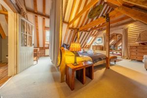 a bedroom with a bed and a table with a lamp at Belchamp Hall Hayloft in Belchamp Otten