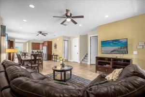 a living room with a leather couch and a flat screen tv at GREAT HOUSE Near Disney, Private Pool in Orlando