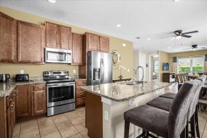 a kitchen with stainless steel appliances and wooden cabinets at GREAT HOUSE Near Disney, Private Pool in Orlando