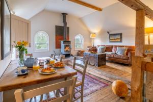 una sala de estar con una mesa y un sofá en Belchamp Hall Mill, en Belchamp Otten
