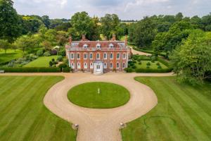 una vista aérea de una casa grande con una gran entrada circular en Belchamp Hall Mill, en Belchamp Otten